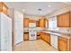 Bright kitchen featuring white appliances, wooden cabinets, and tile flooring at 11816 Orense Dr, Las Vegas, NV 89138