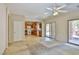 Open-concept living room and kitchen with tile floors, carpet, and sliding glass doors to the backyard at 11816 Orense Dr, Las Vegas, NV 89138