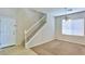 Open foyer and carpeted living room area featuring white staircase, tile flooring, and natural light at 11816 Orense Dr, Las Vegas, NV 89138