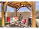 Covered seating area with comfortable seating and a fire pit, perfect for outdoor entertaining at 129 Barton Bay Ave, North Las Vegas, NV 89031