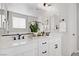 Bright bathroom features a dual sink vanity, large mirror, modern fixtures, and elegant tilework at 129 Barton Bay Ave, North Las Vegas, NV 89031