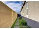 Side yard walkway with stepping stones, garden bed, and exterior wall under a blue sky at 129 Barton Bay Ave, North Las Vegas, NV 89031
