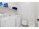 Bright laundry room with white washer, white dryer, and plenty of shelf storage space at 129 Barton Bay Ave, North Las Vegas, NV 89031