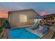 Backyard pool with sun loungers, shaded seating area, and desert landscaping at 129 Barton Bay Ave, North Las Vegas, NV 89031