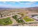 Sweeping aerial view of a residential area with sports fields, community areas, and mountains on the horizon at 1387 Minuet St, Henderson, NV 89052