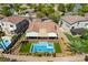 Aerial view of a backyard with a sparkling pool, spa, covered patio, and lush landscaping at 1387 Minuet St, Henderson, NV 89052