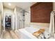 Bathroom showcasing a tub, glass enclosed shower, decorative wallpaper and a walk-in closet at 1387 Minuet St, Henderson, NV 89052