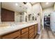 Bathroom showcasing double sinks, a glass shower, decorative wallpaper, and access to a walk-in closet at 1387 Minuet St, Henderson, NV 89052