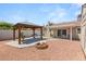 Relaxing backyard with a pergola, fire pit, covered patio, and mature desert landscaping at 1505 Irene Dr, Boulder City, NV 89005