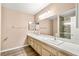 Bathroom with dual sinks, large mirror, and walk-in shower at 1505 Irene Dr, Boulder City, NV 89005