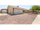Charming exterior features a two-car garage and a spacious driveway with unique brick pavers at 1505 Irene Dr, Boulder City, NV 89005