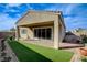 Covered patio with sliding glass doors, artificial turf, and paver pathway at 161 Cabo Cruces Dr, Henderson, NV 89011