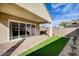This backyard features a covered patio with sliding glass doors and low-maintenance landscaping at 161 Cabo Cruces Dr, Henderson, NV 89011