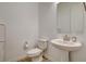 Powder room with pedestal sink, toilet, and wood-look tile flooring offering practical elegance at 161 Cabo Cruces Dr, Henderson, NV 89011