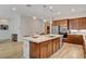 Modern kitchen features an island with a sink, stainless steel appliances, and wood cabinetry at 161 Cabo Cruces Dr, Henderson, NV 89011