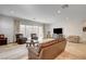 Bright living room with sliding glass doors, light tile floors, neutral walls, and comfortable leather furniture at 161 Cabo Cruces Dr, Henderson, NV 89011