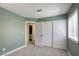 Well-lit bedroom featuring pale green walls, a window, and a closet for ample storage at 1833 Winners Cup Dr, Las Vegas, NV 89117