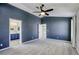 Comfortable bedroom boasts soft carpeting, dark accent wall and a ceiling fan with light at 1833 Winners Cup Dr, Las Vegas, NV 89117