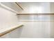 A walk-in closet includes shelving and wooden clothing rods on a white wall at 1833 Winners Cup Dr, Las Vegas, NV 89117
