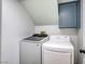 Bright laundry room features a washer, dryer and blue upper cabinet for storage at 1833 Winners Cup Dr, Las Vegas, NV 89117