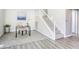 Office area with grey carpet, staircase, white railing, and a view into a naturally lit room at 1833 Winners Cup Dr, Las Vegas, NV 89117