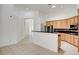 Bright kitchen featuring light wood cabinets, black countertops, and a large island at 2150 Ponticello Dr, Henderson, NV 89052
