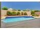 Refreshing pool with blue tile trim surrounded by lush landscaping and a patio at 2150 Ponticello Dr, Henderson, NV 89052