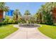 Inviting community area featuring umbrella-covered seating amid lush landscaping and swaying palm trees at 222 Karen Ave # 2506, Las Vegas, NV 89109