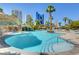Luxurious pool area featuring a unique rock grotto and palm trees against a backdrop of city buildings at 222 Karen Ave # 601, Las Vegas, NV 89109