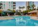 Large pool area with rock features surrounded by swaying palm trees and comfortable lounge chairs at 222 Karen Ave # 601, Las Vegas, NV 89109