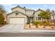Inviting two-story home with a three-car garage, desert landscaping, and manicured front yard at 2250 Tedesca Dr, Henderson, NV 89052