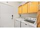 Bright laundry room with side-by-side washer and dryer, and upper cabinets at 2250 Tedesca Dr, Henderson, NV 89052