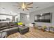 Spacious living room with hardwood floors, a ceiling fan, and an adjacent modern kitchen at 2250 Tedesca Dr, Henderson, NV 89052