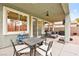 Covered patio with ceiling fan, dining table, and comfortable outdoor seating at 2250 Tedesca Dr, Henderson, NV 89052