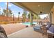 Covered patio with outdoor furniture, TV, and access to a backyard with a pool at 2250 Tedesca Dr, Henderson, NV 89052
