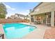 A backyard pool is surrounded by a patio with outdoor seating and landscaped areas at 2250 Tedesca Dr, Henderson, NV 89052
