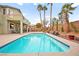 Backyard pool with patio furniture and palm trees in a well-maintained outdoor space at 2250 Tedesca Dr, Henderson, NV 89052