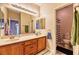 Bathroom featuring a double sink vanity, decorative mirror and adjacent toilet and shower at 2285 Moresca Ave, Henderson, NV 89052