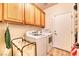 Efficient laundry room with a washer, dryer, storage cabinets, and a drying rack for convenience at 2285 Moresca Ave, Henderson, NV 89052