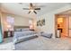 Spacious main bedroom with a ceiling fan, carpet, and a sitting area, offering comfort and style at 2285 Moresca Ave, Henderson, NV 89052