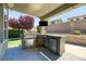 Backyard kitchen featuring built-in grill and refrigerator, ideal for outdoor entertaining at 2285 Moresca Ave, Henderson, NV 89052