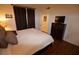 This main bedroom features wood floors, dark furniture, and a view into the bathroom at 230 E Flamingo Rd # 129, Las Vegas, NV 89169