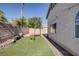A backyard with a basketball hoop, brick walls, a small tree, and artificial grass in a desert climate at 2410 Morocco Ave, North Las Vegas, NV 89031