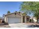 Inviting single-Gathering home featuring a two-car garage and desert-style front yard at 2410 Morocco Ave, North Las Vegas, NV 89031
