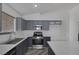 Well-lit kitchen showcasing gray cabinetry, stainless steel appliances, and white countertops at 2410 Morocco Ave, North Las Vegas, NV 89031