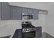 Modern kitchen featuring gray cabinets, stainless steel appliances, and white countertops at 2410 Morocco Ave, North Las Vegas, NV 89031