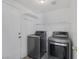 Well-equipped laundry room featuring modern washer and dryer, plus overhead shelving for storage at 2410 Morocco Ave, North Las Vegas, NV 89031