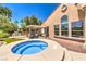 Backyard with spa, seating area, grill, and lush landscaping at 27 Via Paradiso St, Henderson, NV 89011