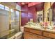 Bathroom including shower with gold trim, a sink with granite countertop, and decorations at 27 Via Paradiso St, Henderson, NV 89011