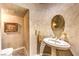 Elegant powder room with a pedestal sink, decorative mirror, and textured walls at 27 Via Paradiso St, Henderson, NV 89011